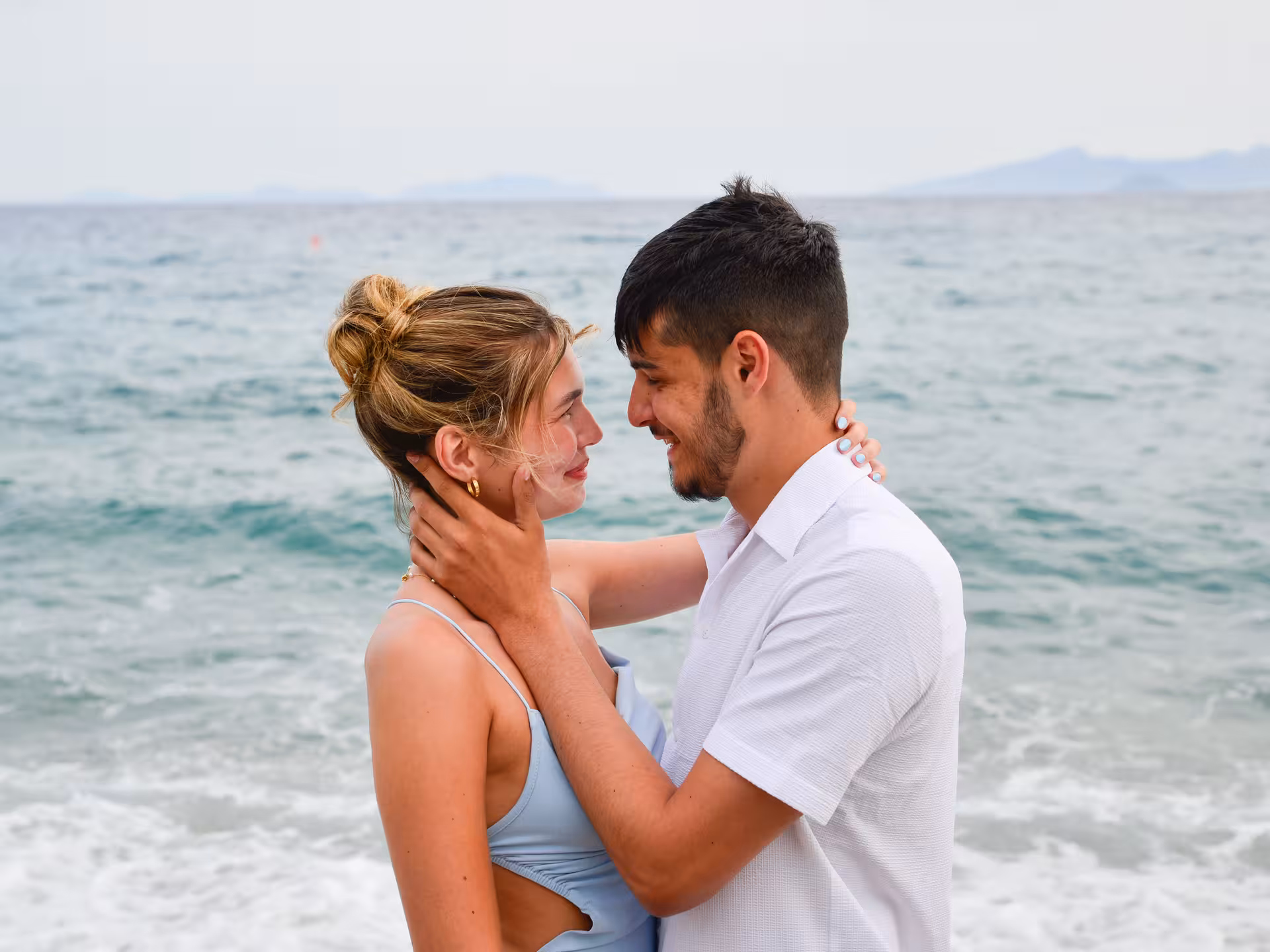 Loving couple sharing a tender moment by the ocean at Heraklion Venetian Port during a private photoshoot.