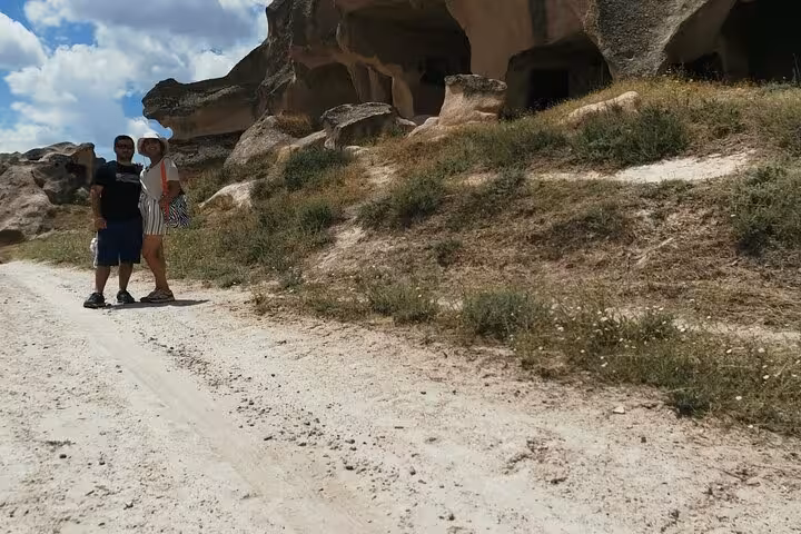 Couple hiking past ancient cave dwellings on a 2-day private trekking tour in Cappadocia, Göreme valleys