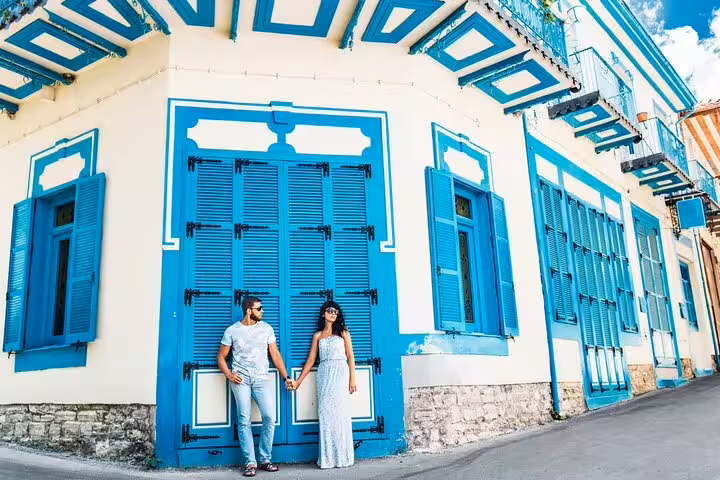 Couple holding hands by blue shutters in Mykonos Town, private photoshoot with professional photographer