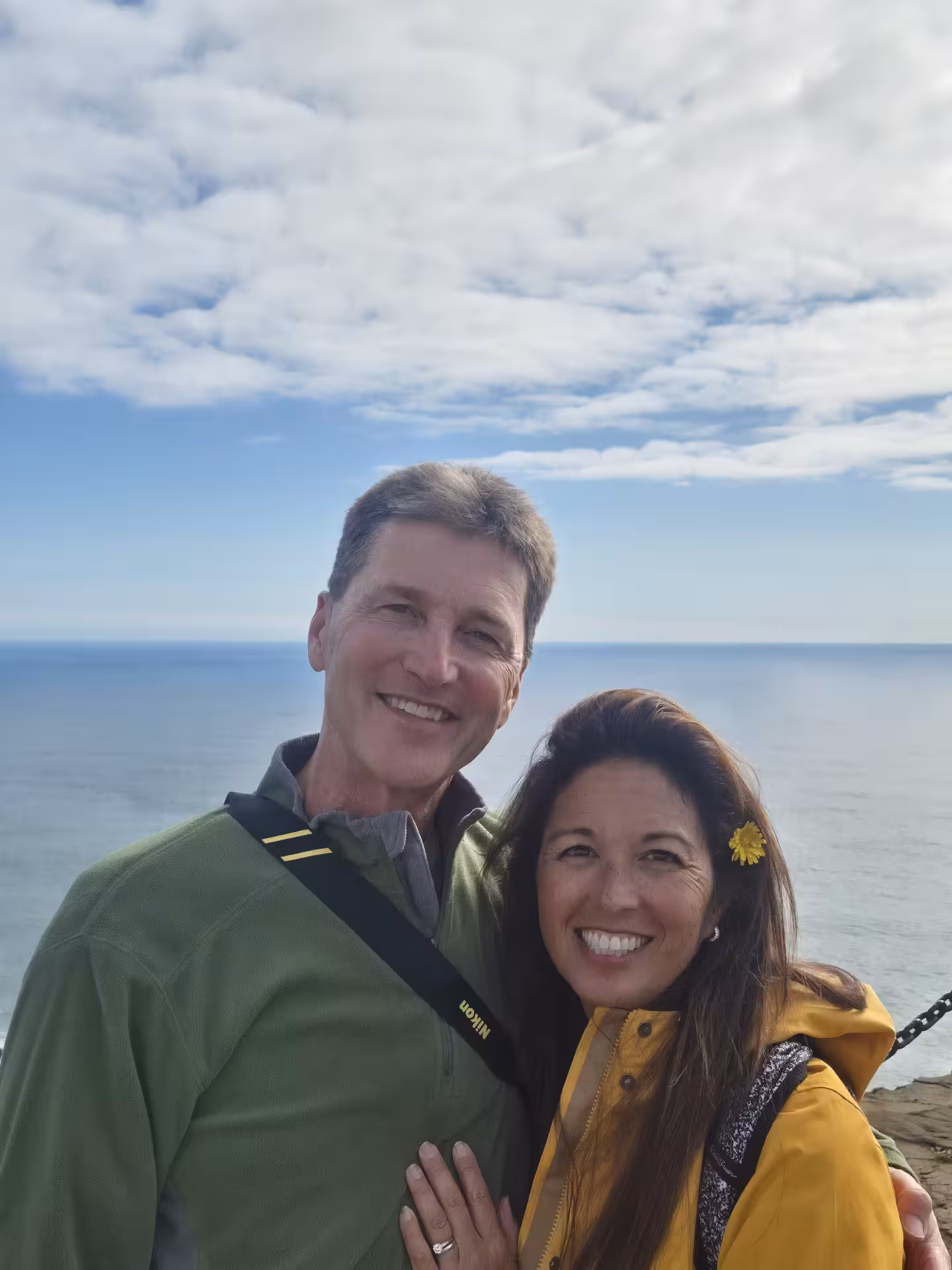 Smiling couple posing by the ocean on Iceland's south coast on a cloudy day