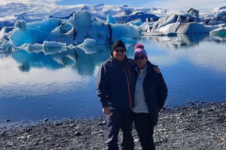 Couple posing at Jökulsárlón glacier lagoon with blue icebergs on Iceland's south coast
