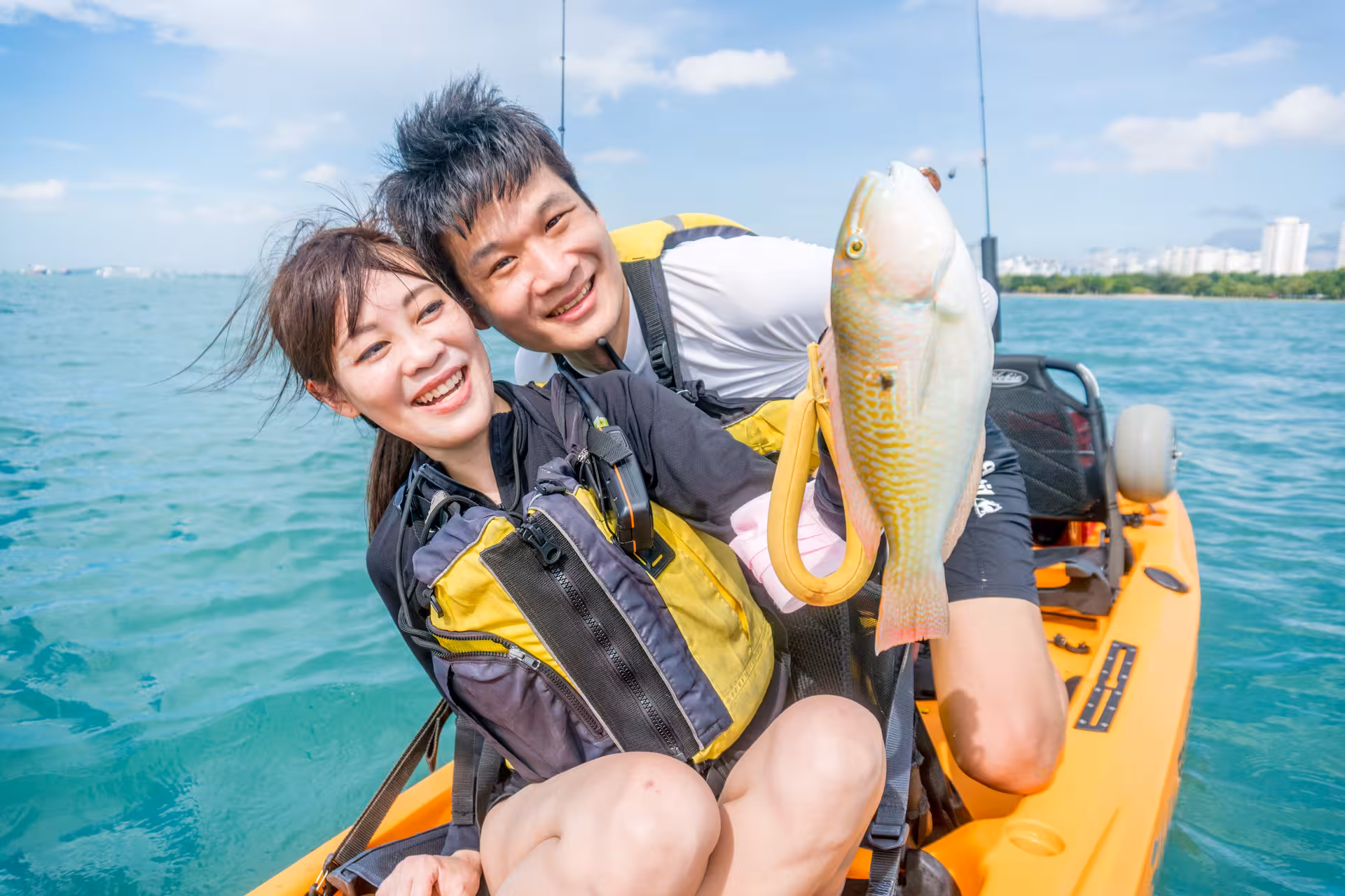 Happy couple showcasing their fresh catch while enjoying kayak fishing on the East Coast.