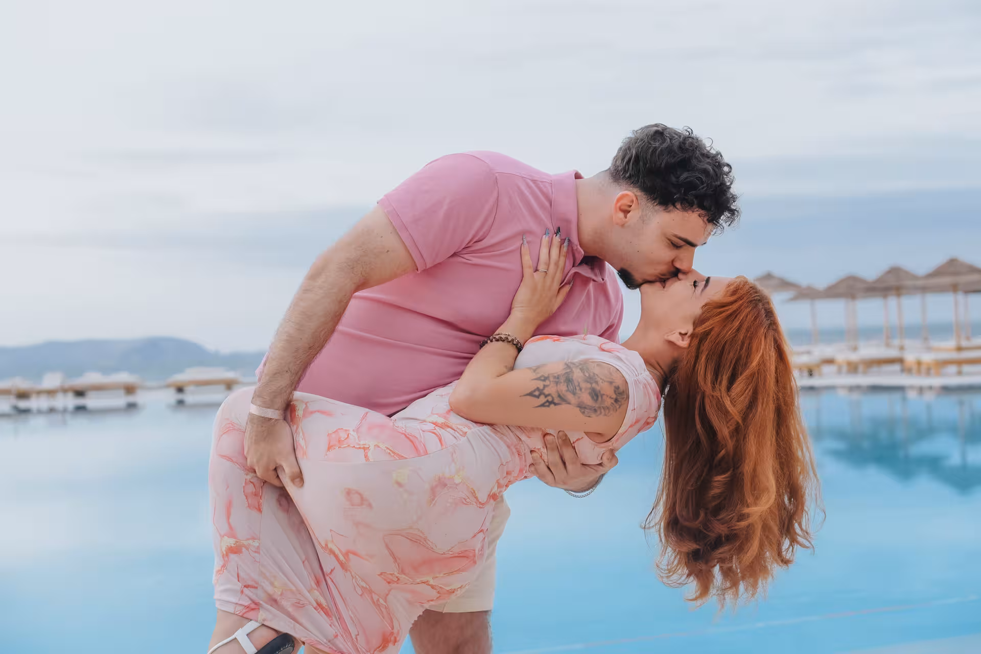 Romantic couple kissing by the water at Heraklion Venetian Port during a picturesque photoshoot, perfect for capturing love.