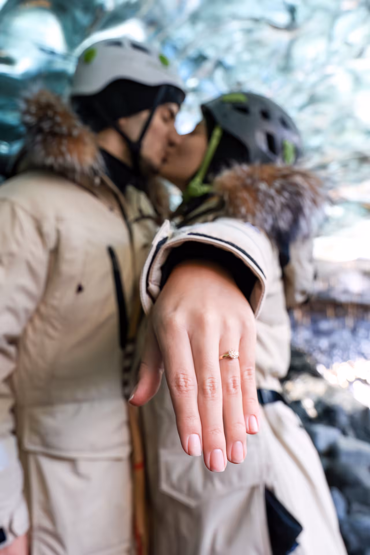 Couple kissing inside Iceland ice cave showing engagement ring on romantic Iceland sunrise proposal glacier lagoon tour