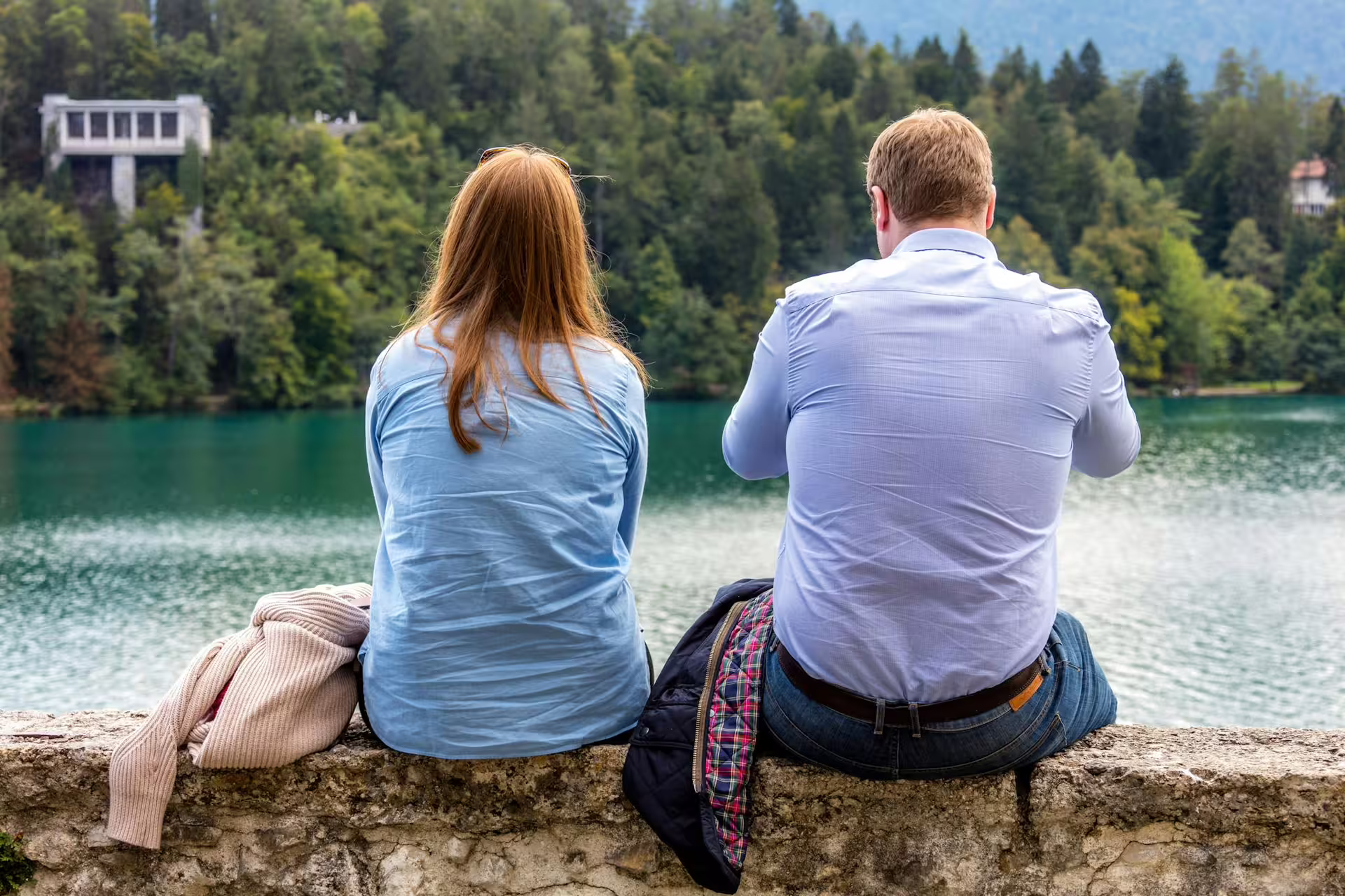 Couple relaxing by Lake Bled shore in summer, a scenic stop on Bled Castle and boat ride tour