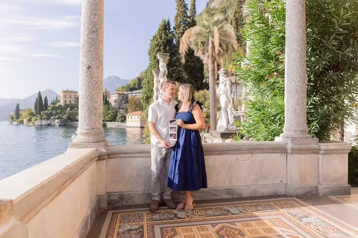 Couple posing on a Lake Como villa terrace with statues, captured by a private travel photographer