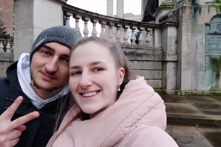 Couple smiling at Liverpool historic monument during ghost walking tour