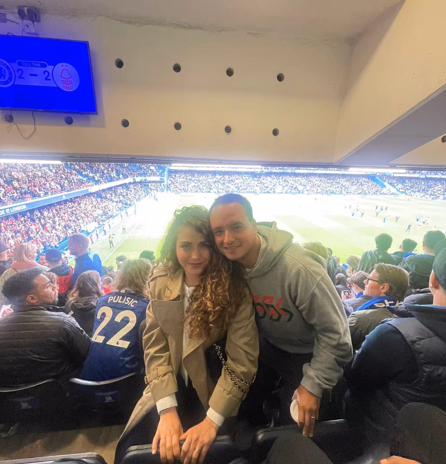 Couple with local host in Stamford Bridge stands, London football game experience with match atmosphere and fans