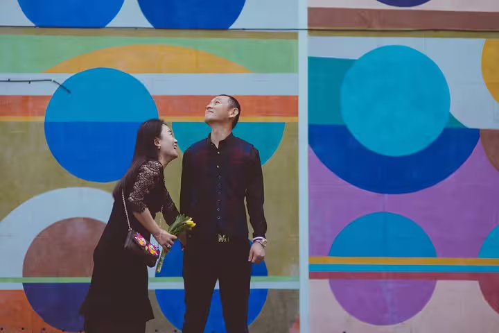 Couple enjoying a colorful mural backdrop in London, ideal for a vibrant personal travel photography experience.