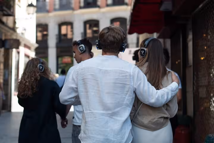 Couple embracing on a CityVoice immersive walking tour in Madrid, experiencing the city's charm with headphones.