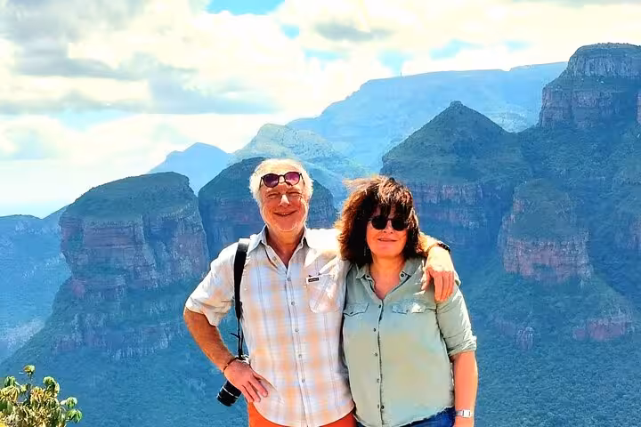 Couple enjoying breathtaking views of lush green mountains on a Panorama Guided Experience tour.