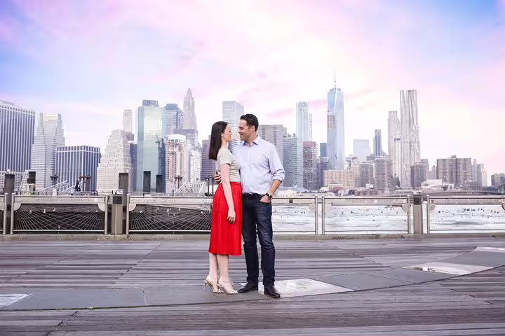 Couple embracing with New York skyline backdrop during private photographer tour.