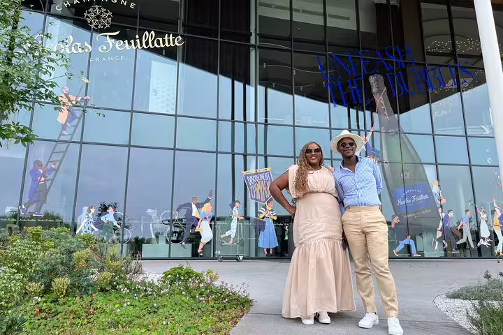 Couple outside Champagne Nicolas Feuillatte visitor center in Reims on a Paris day trip for cellar tour and tasting