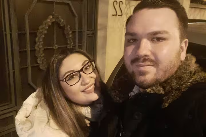Couple smiling at night in Bucharest Old Town street during self-guided tour