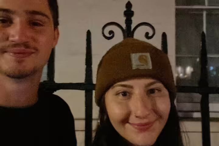 Two young people smiling at night during a haunted London ghost hunt walking tour
