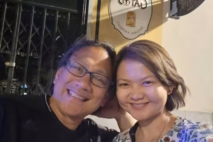 Two smiling people posing together at night outside a Madrid venue