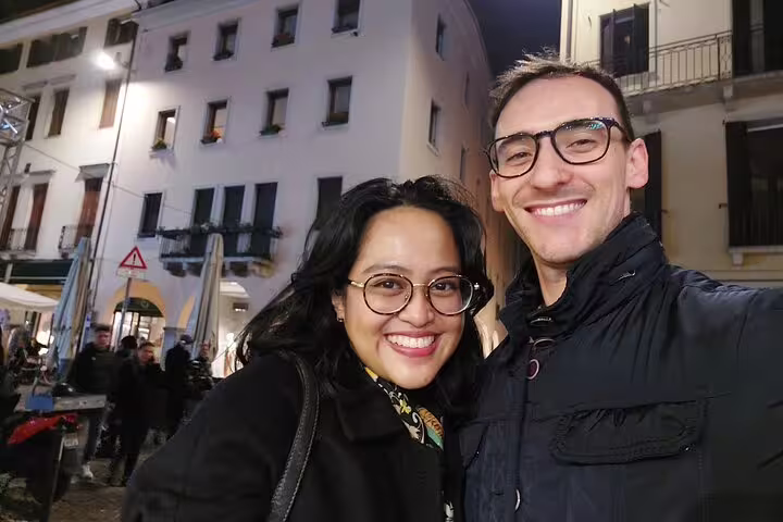 Couple smiling at night during a self-guided walking tour in Padua, Italy