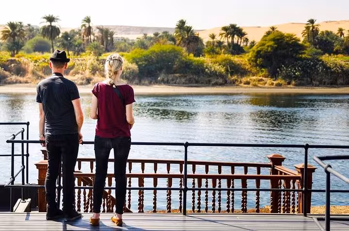 Couple on Nile cruise deck viewing river and palm-lined shore, part of 10-day Cairo pyramids to Hurghada tour