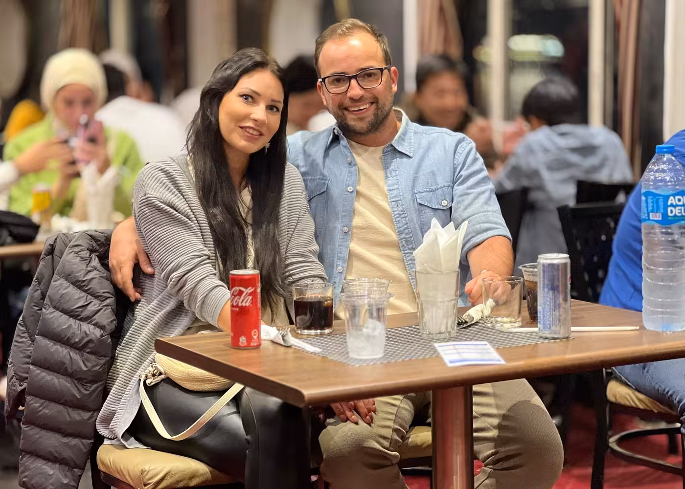 Couple seated at table on Nile River night dinner cruise in Cairo, enjoying drinks and evening ambiance