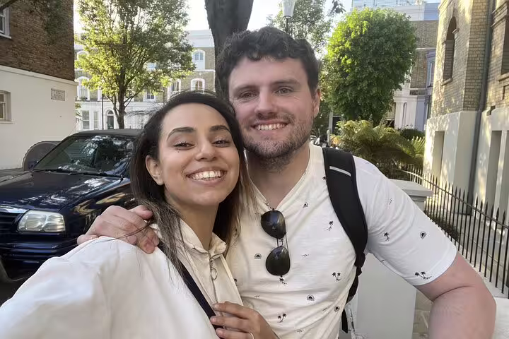 Couple smiling on a sunny Notting Hill street during a self-guided walking tour