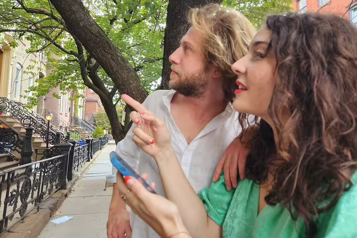 Couple exploring NYC streets with phone during self-guided treasure hunt tour