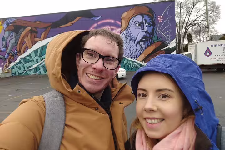 Couple smiling in front of colorful street art mural in Ottawa