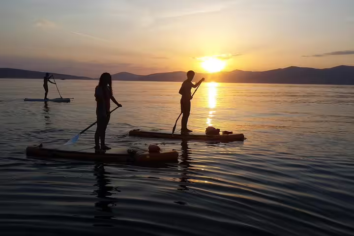 Couple paddleboarding on calm Adriatic at golden hour on Split sunset stand up paddle tour with wine included