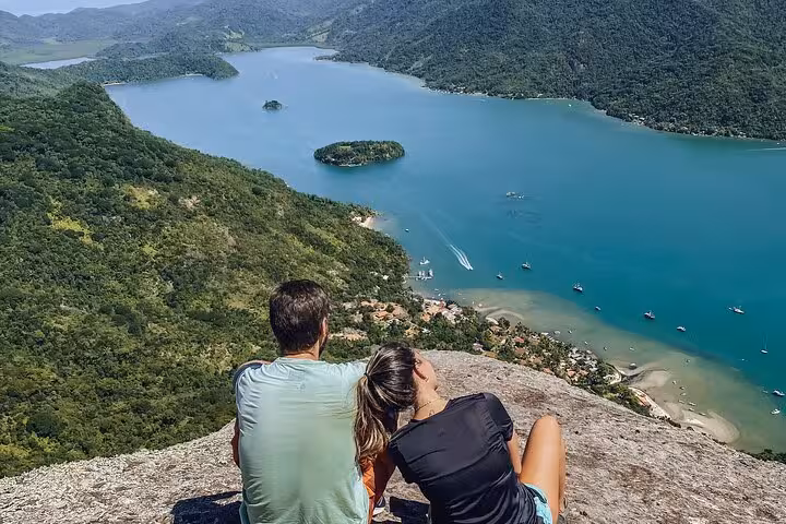 Couple admires panoramic vistas over serene waters at Peak Sugar Bread, perfect for an unforgettable adventure experience.