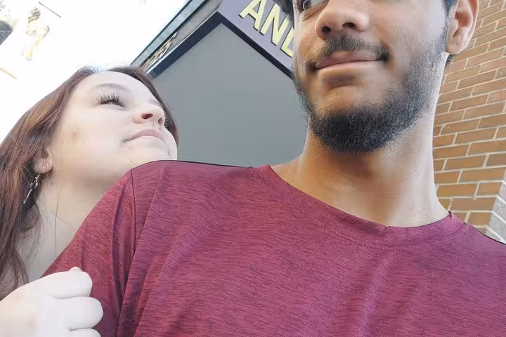 Couple smiling outdoors near brick building during Pasadena walking tour spy mission game