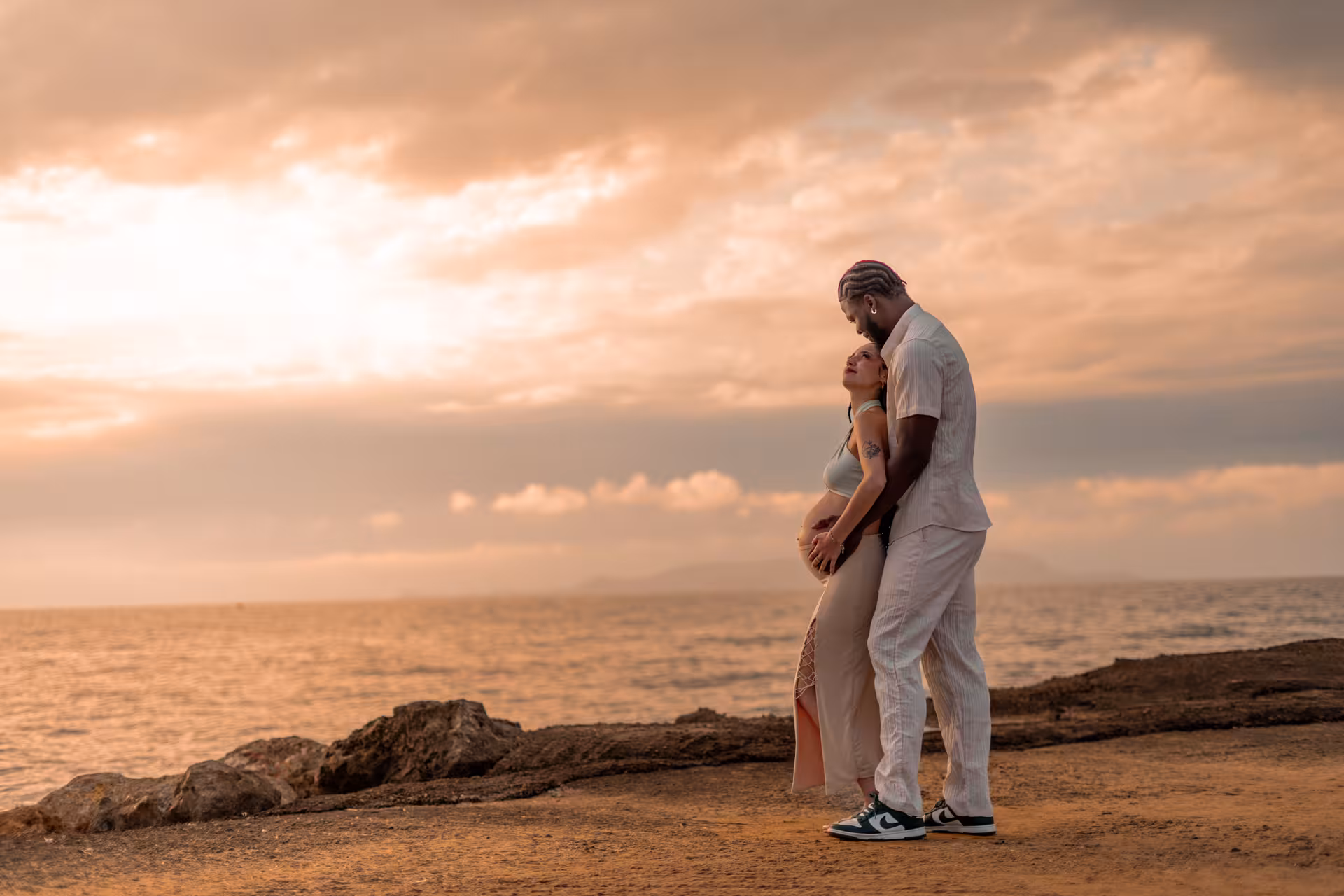 Tender moment between couple at Heraklion Venetian Port during sunset, ideal for a romantic photoshoot experience.