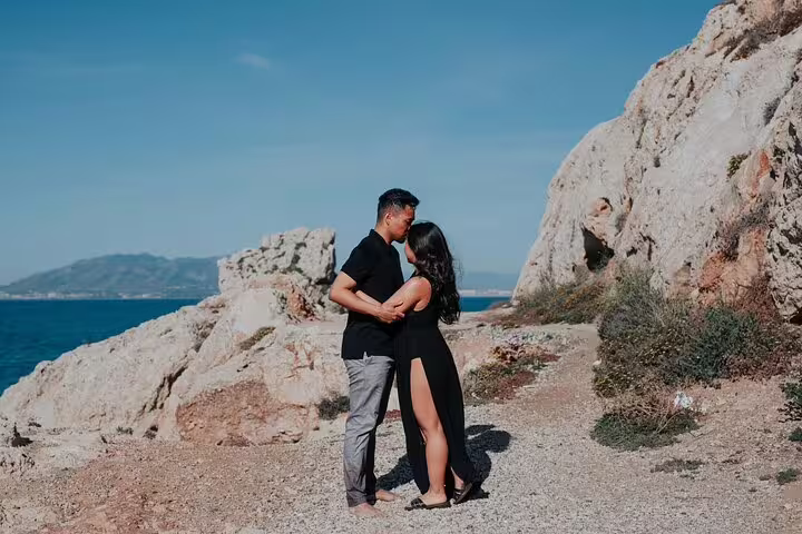 Couple embracing during a private photoshoot on a rocky coastline in Marbella with stunning sea views.