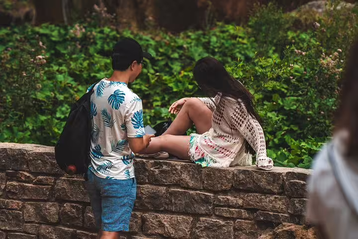 Couple relaxing by stone wall in Plitvice Lakes National Park during a private tour in Croatia