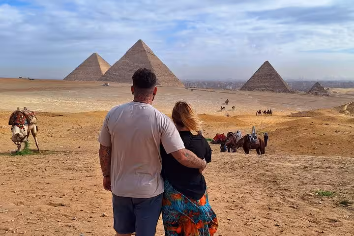 Couple embraces while admiring the iconic Pyramids of Giza, a highlight of the 2-day private Cairo tour experience.