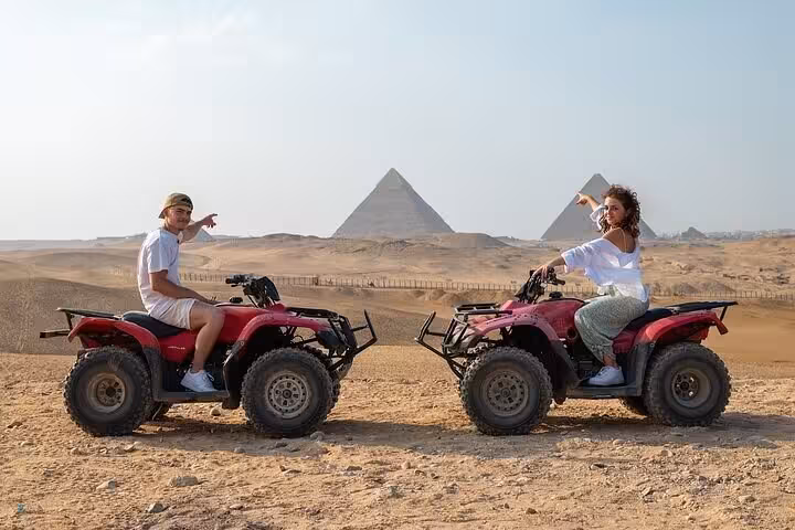 Couple on quad bikes facing the Giza Pyramids, private desert ATV ride tour near the Sphinx, Cairo Egypt