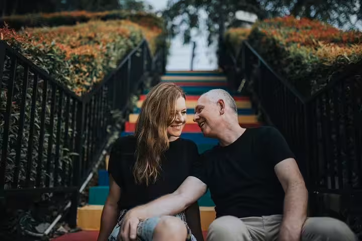 Couple sitting on colorful rainbow stairs in Singapore, romantic photoshoot with personal travel photographer tour