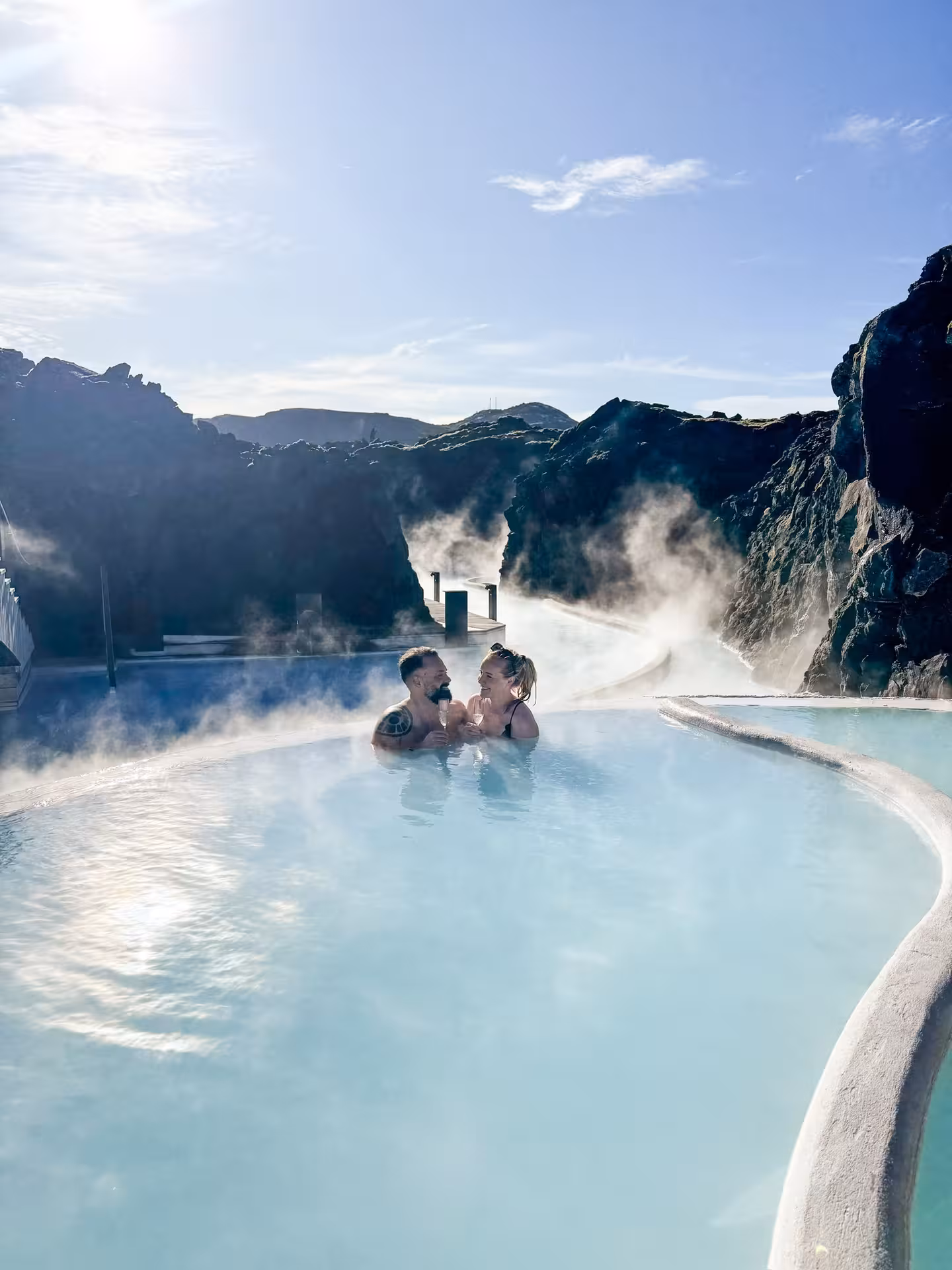 Romantic couple relaxing in Iceland Blue Lagoon geothermal spa with steaming turquoise waters and lava rocks