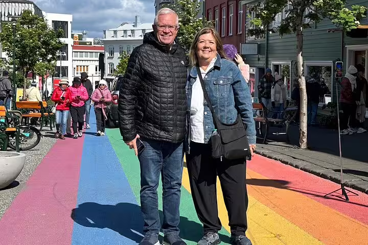 Couple smiling on rainbow street in Reykjavik city center on sunny day