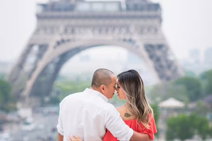Couple sharing a romantic moment in front of the Eiffel Tower in Paris