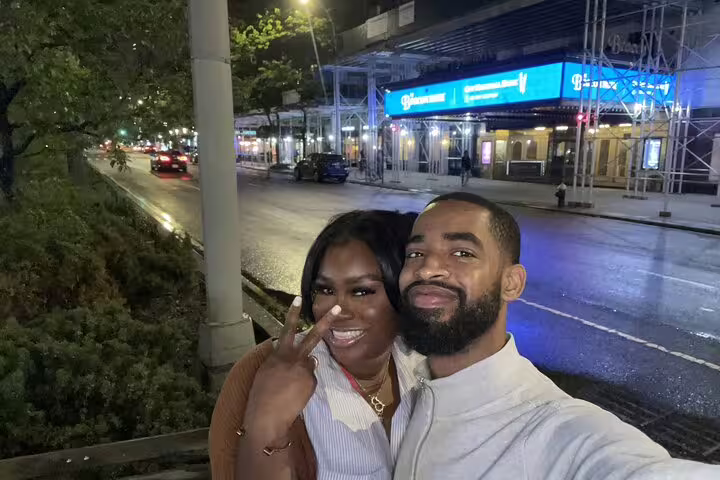 Couple taking a selfie on a NYC street at night during a romantic walking tour