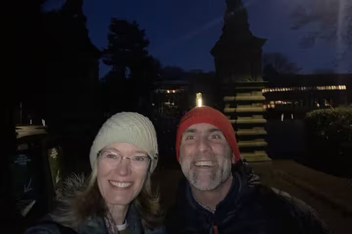 Smiling couple wearing winter hats taking a selfie outdoors at night in Edinburgh