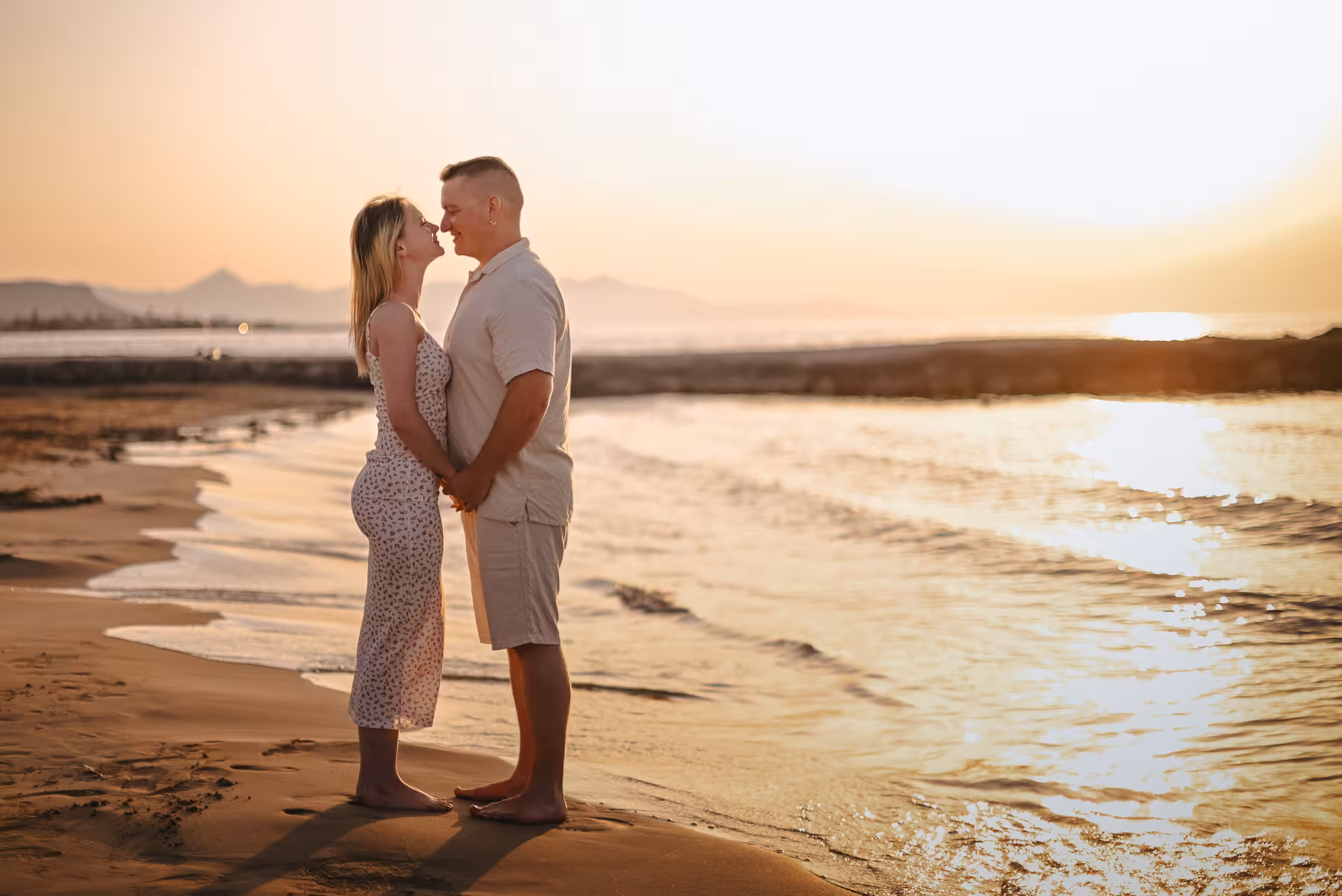 Couple embraces on Gouves beach at sunset, capturing romantic moments during a private photoshoot.