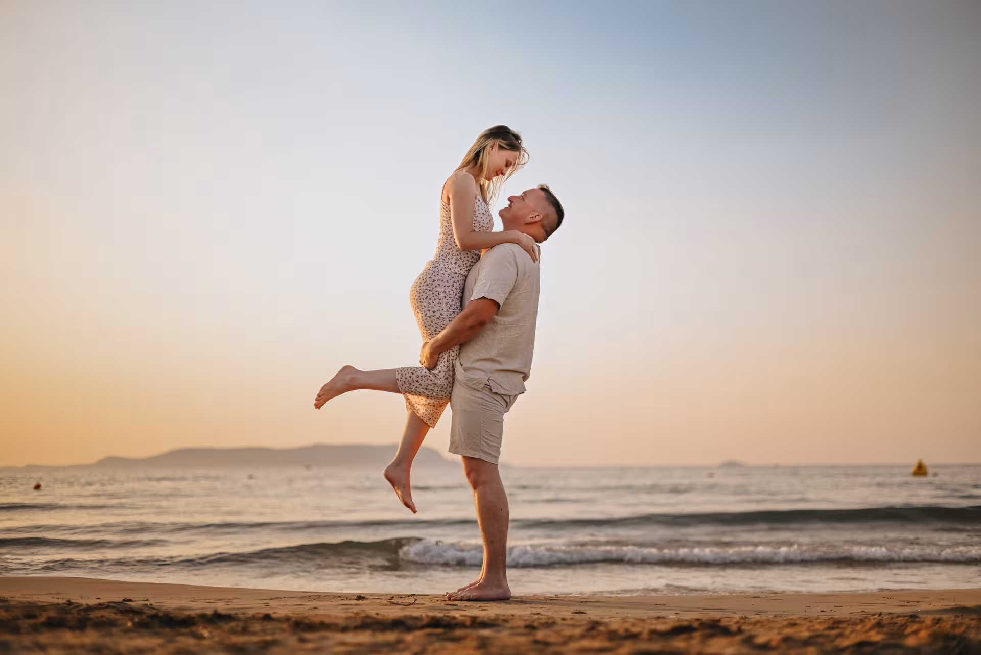 Couple sharing a joyful moment on a Gouves beach at sunset, perfect for a romantic private photoshoot session.