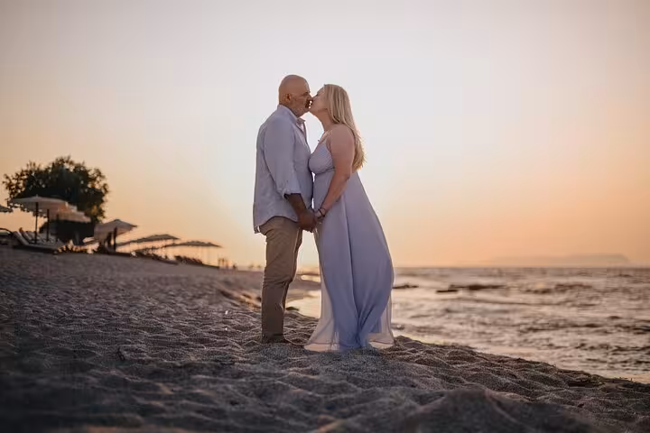 Couple sharing a romantic sunset kiss on Anisaras beach, perfect for a private photoshoot experience.