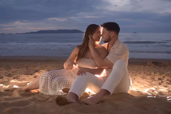 Couple enjoying a romantic sunset photoshoot on the sandy beach of Hersonissos, Crete.