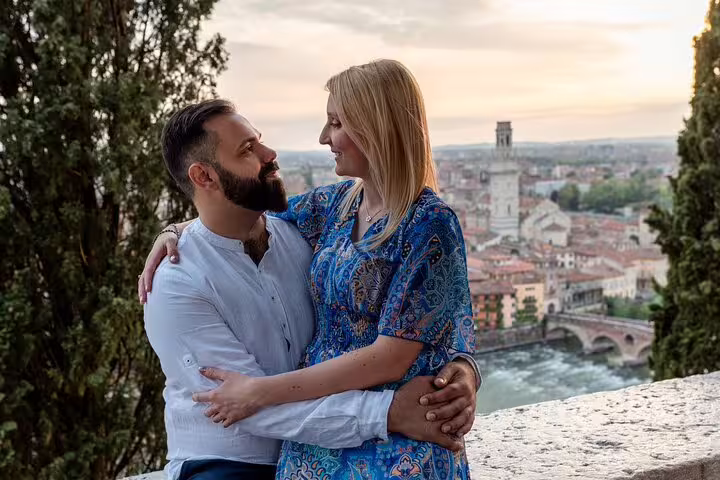 Couple embracing at sunset with Verona's skyline in the background, capturing romantic moments on a professional photoshoot.