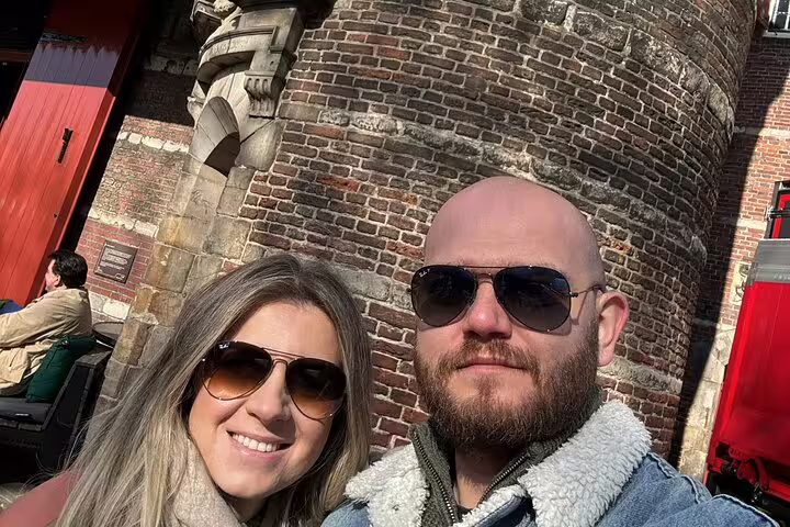 Couple smiling together on Amsterdam romantic city walking tour near historic brick building