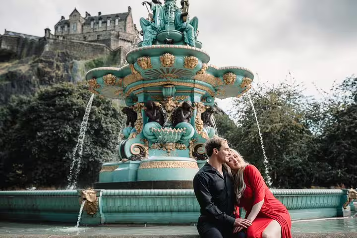 Couple posing by Ross Fountain with Edinburgh Castle backdrop, romantic private photoshoot with pro photographer