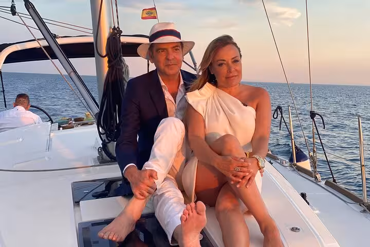 Couple relaxing on a sailboat at sunset in Barcelona, private sailing with open bar and snacks included