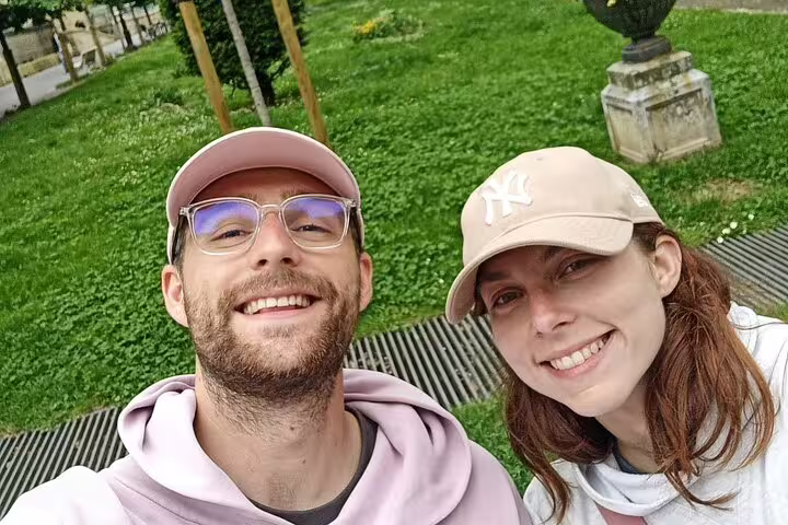 Couple smiling outdoors in a green park during a self-guided walking tour in San Sebastian
