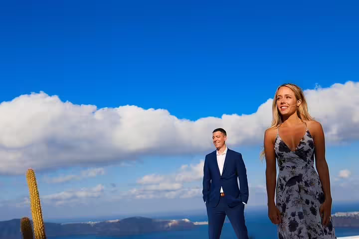 Couple posing against a stunning Santorini backdrop with clear blue skies on a travel photography tour.